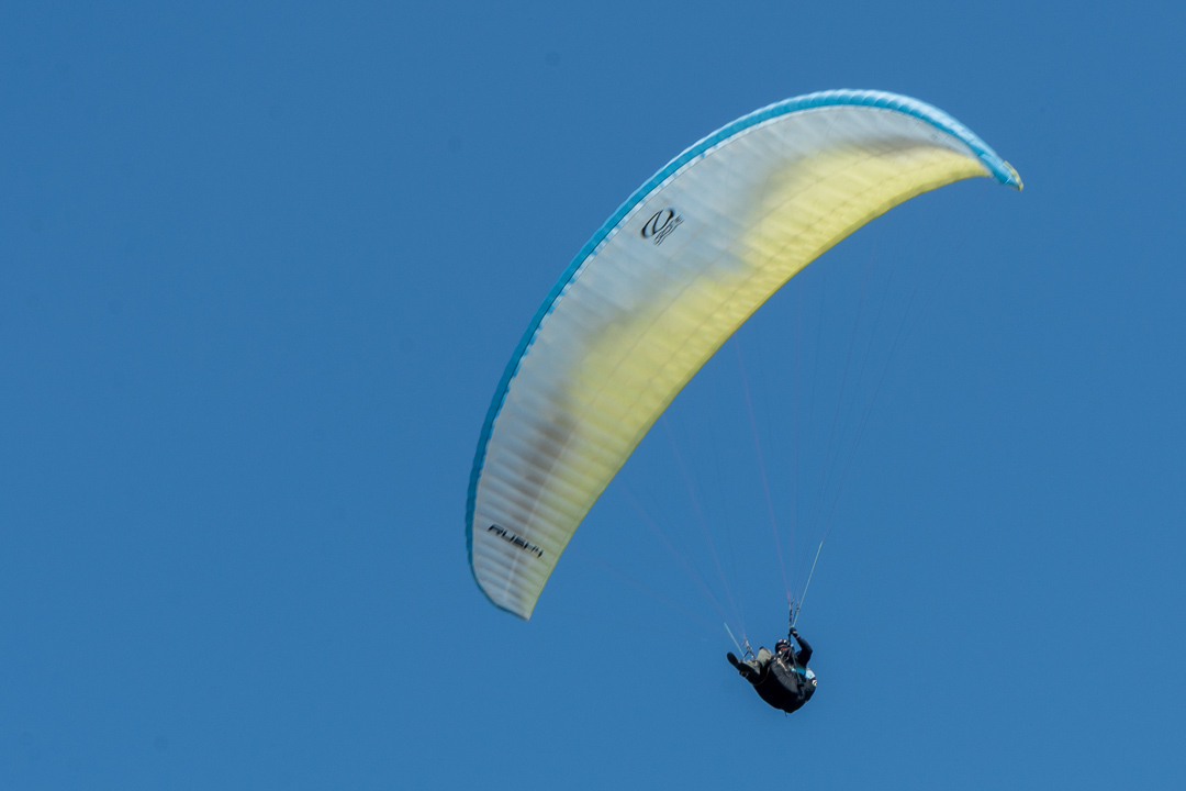 phot of a hang glider against a blue sky